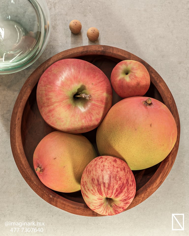 Tazón de madera con manzanas rojas y amarillas sobre superficie de concreto